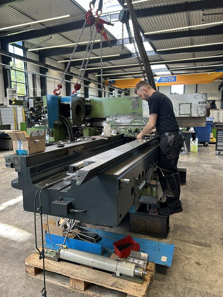 Maschinenschlosser bei der Montage einer Werkzeugmaschine im industriellen Umfeld